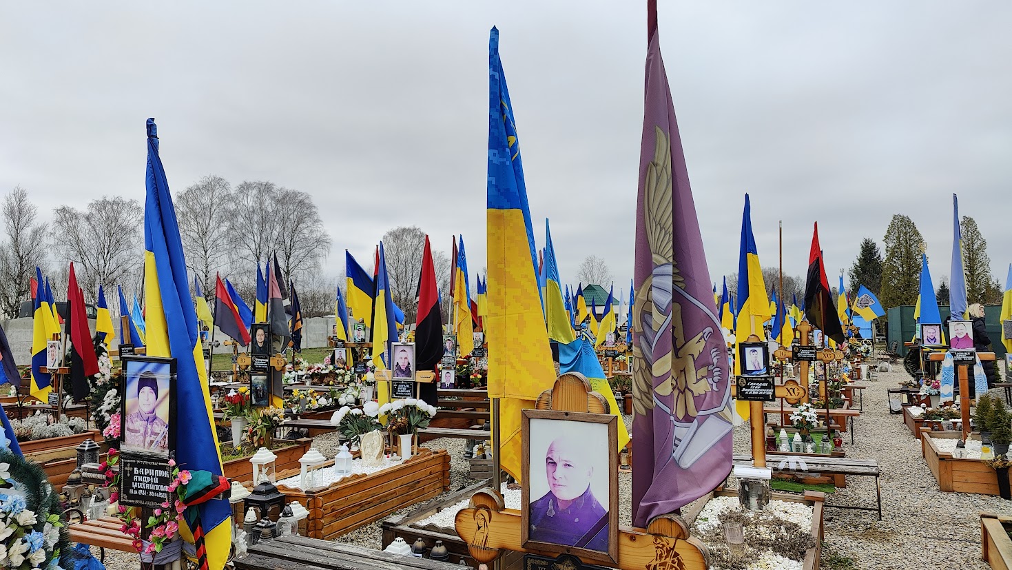 Ukrainalaisen pikkukylän hautausmaa, joka täynnä liehuvia Ukrainan lippuja