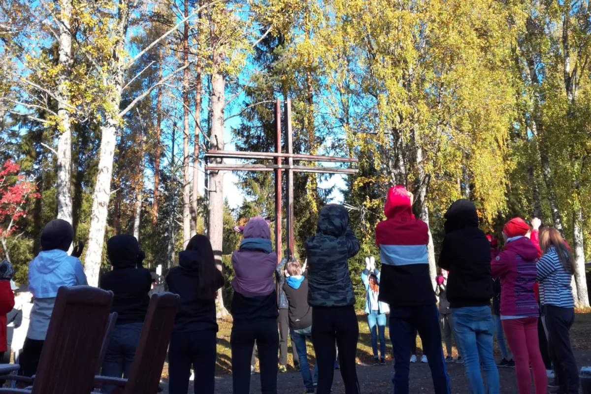 Nuoret ristin ympärillä.